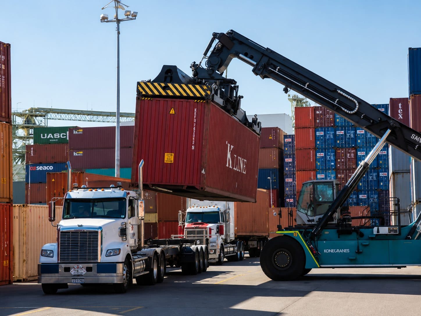 Crane loading a shipping container onto a truck at port